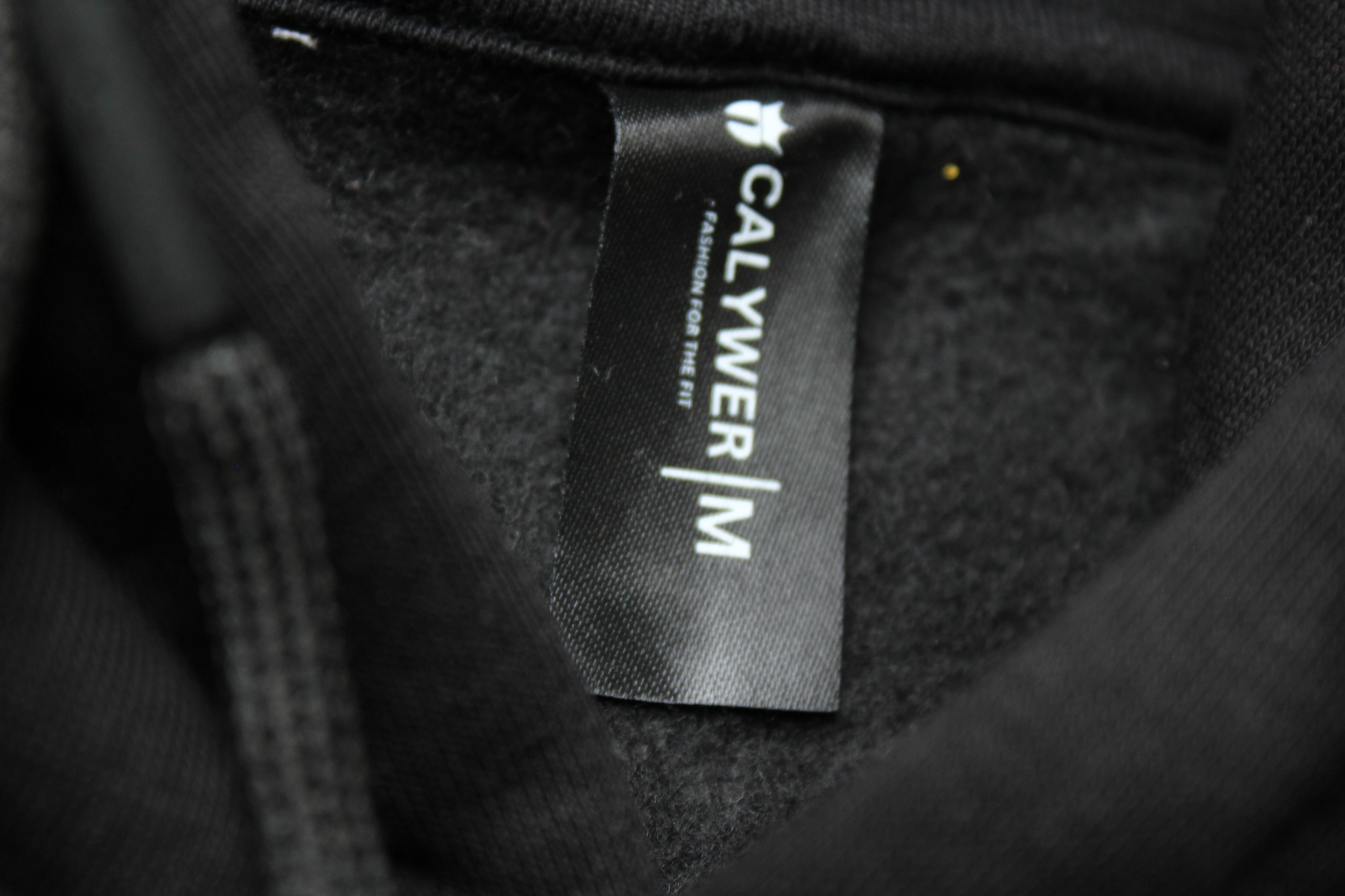 Calywer brand label on a textured black fabric background